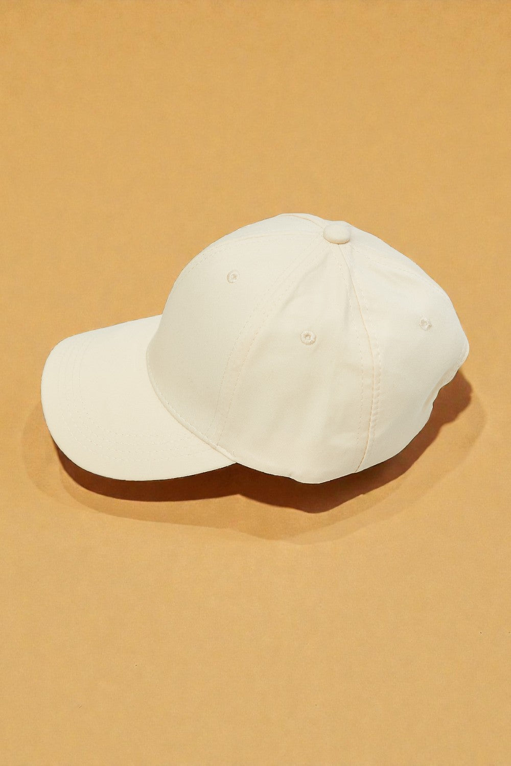 White baseball cap on a beige background