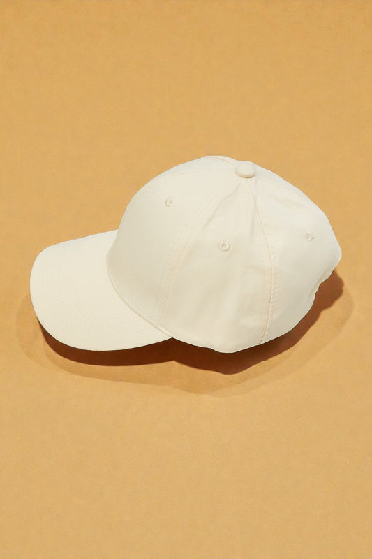 White baseball cap on a beige background