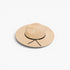 A light beige wide-brim fedora hat with a black ribbon band tied in a bow at the front, shown on a clean white background.