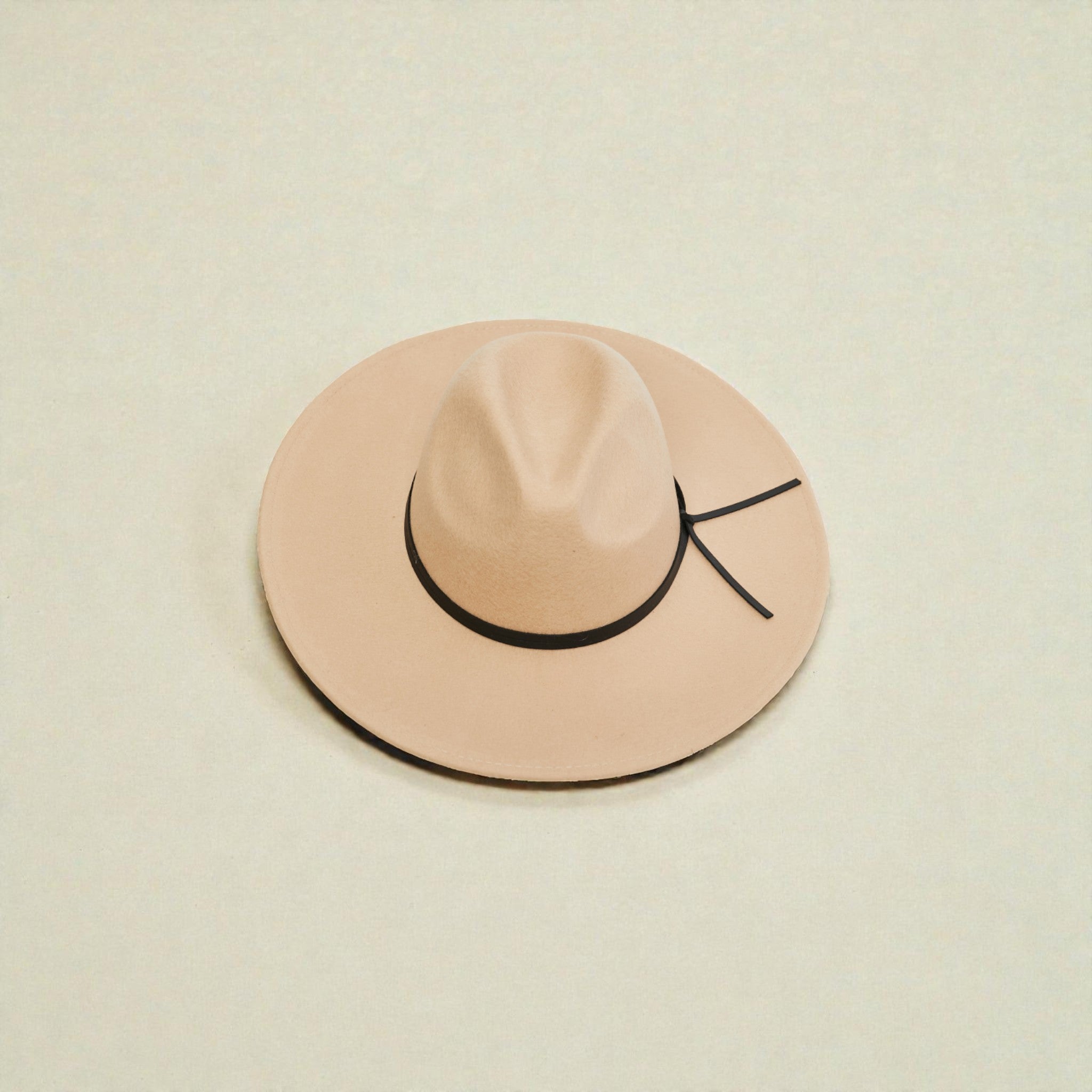 Beige hat with a black band on a beige background