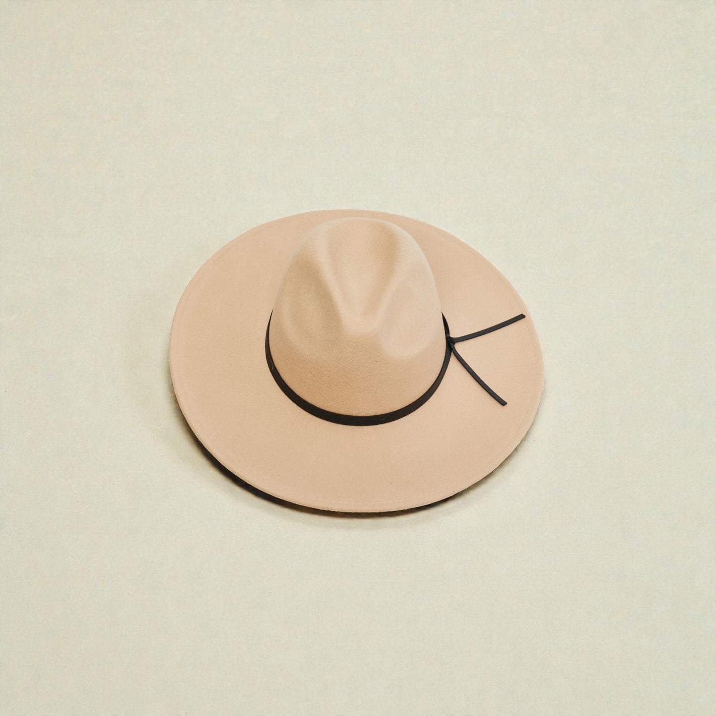 Beige hat with a black band on a beige background