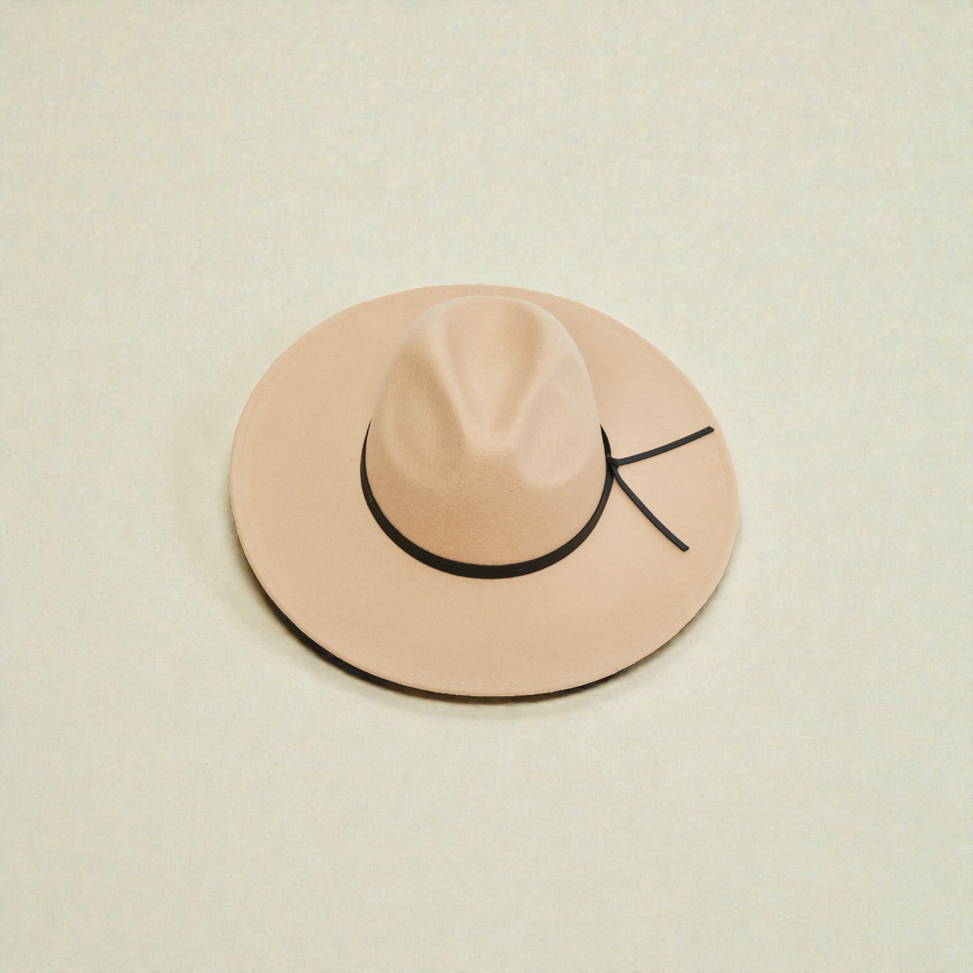 Beige hat with a black band on a beige background
