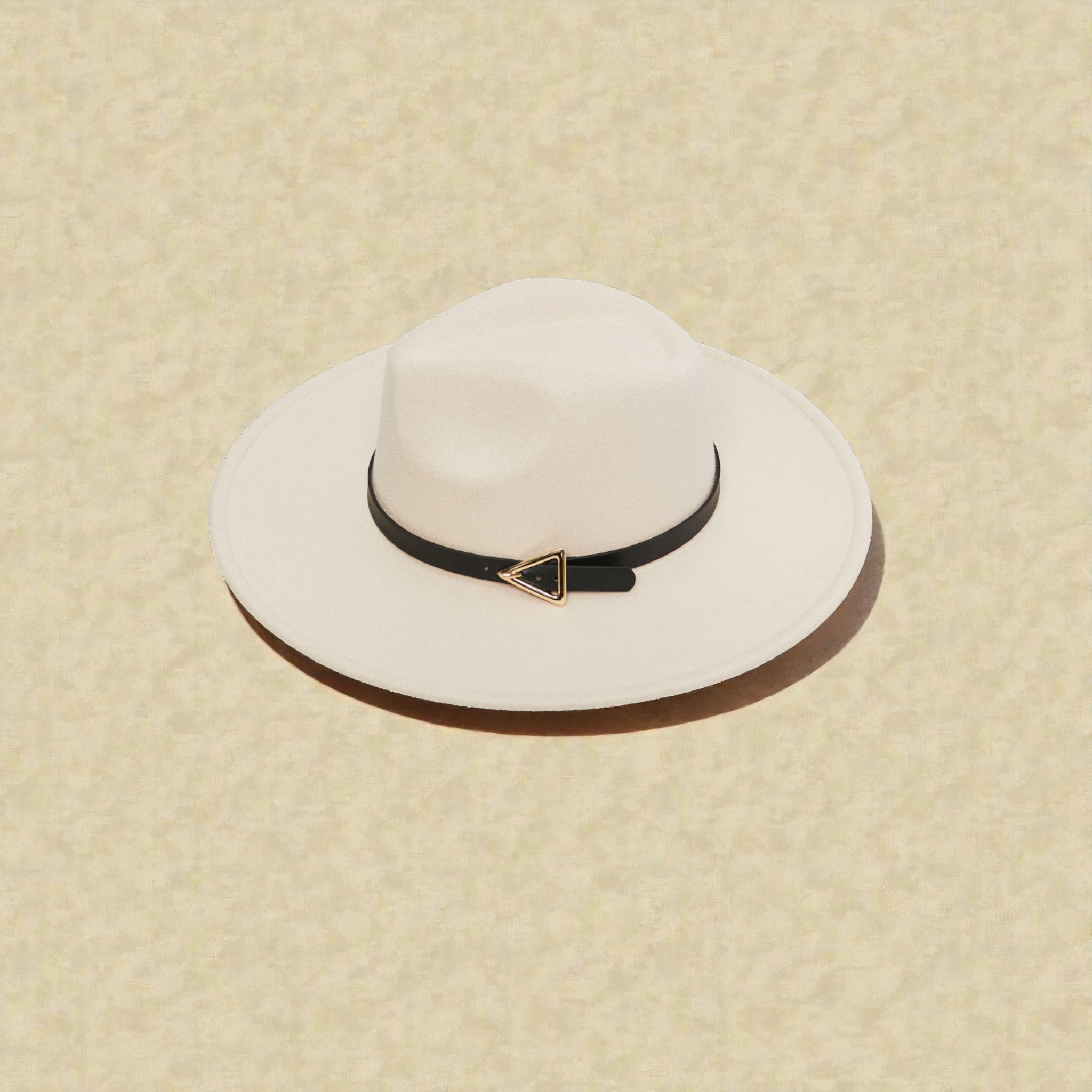 White wide-brimmed hat with a black band featuring a gold triangle on a beige background