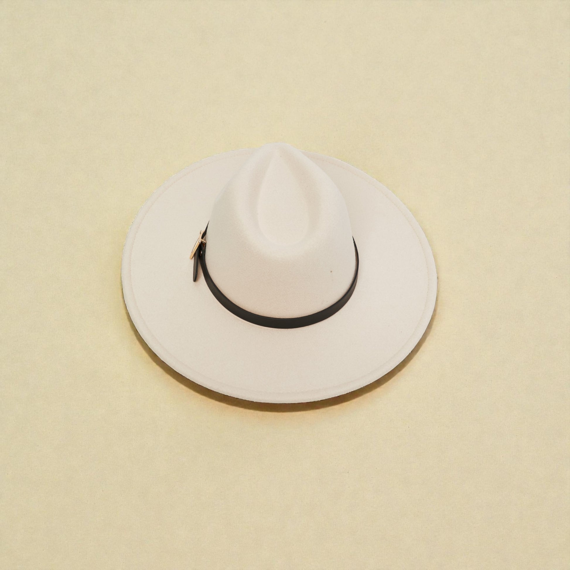 White wide-brimmed hat with a black band on a beige background