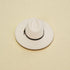White wide-brimmed hat with a black band on a beige background