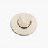 A light beige wide-brim fedora hat with a black band and a small gold buckle, photographed from a top-down angle on a white background.