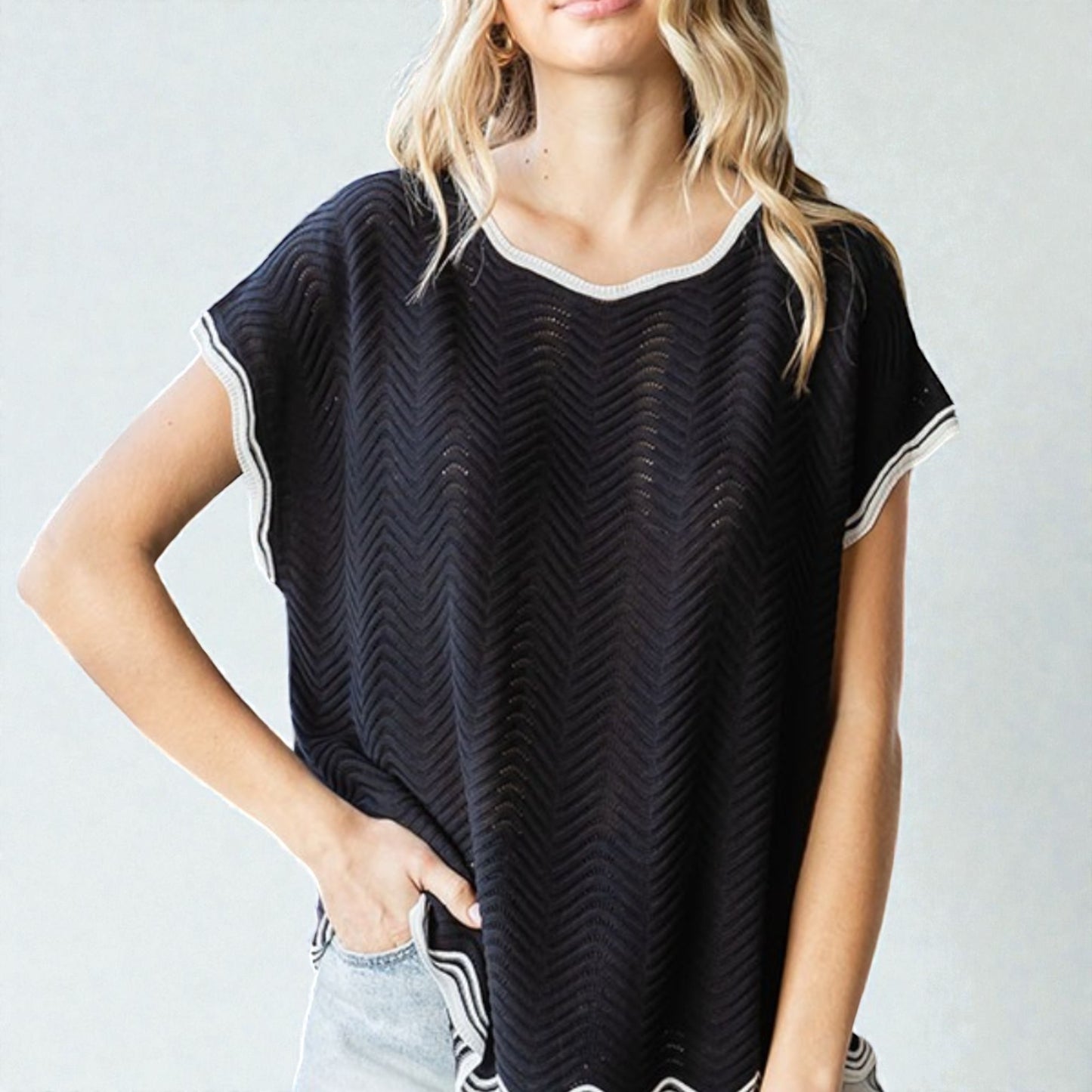 Woman wearing a black patterned t-shirt against a plain background