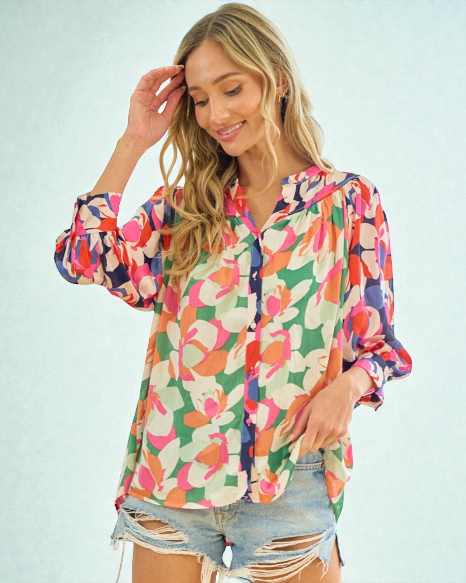 Woman wearing a colorful floral blouse against a light blue background