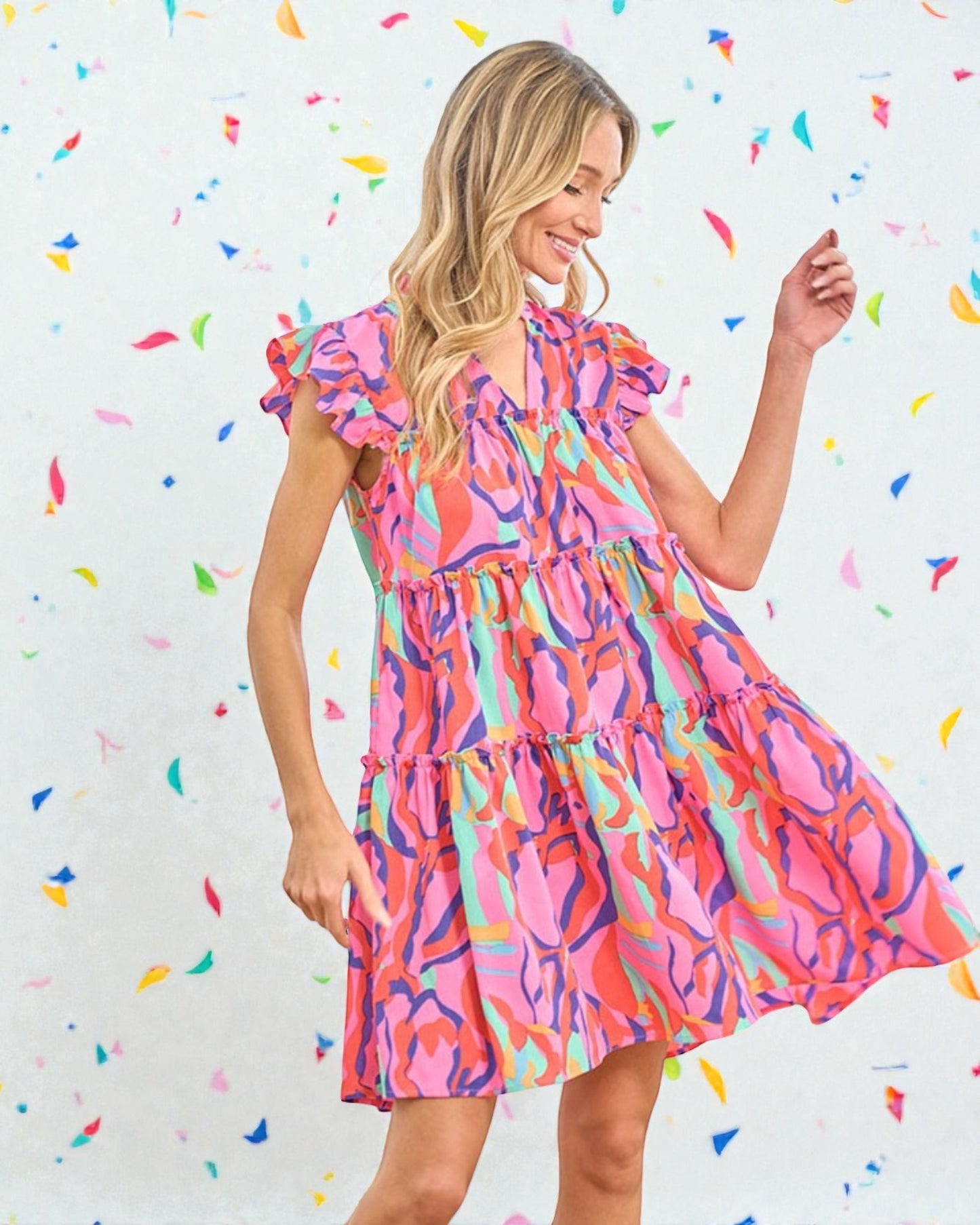 Woman wearing a colorful dress against a confetti-patterned background