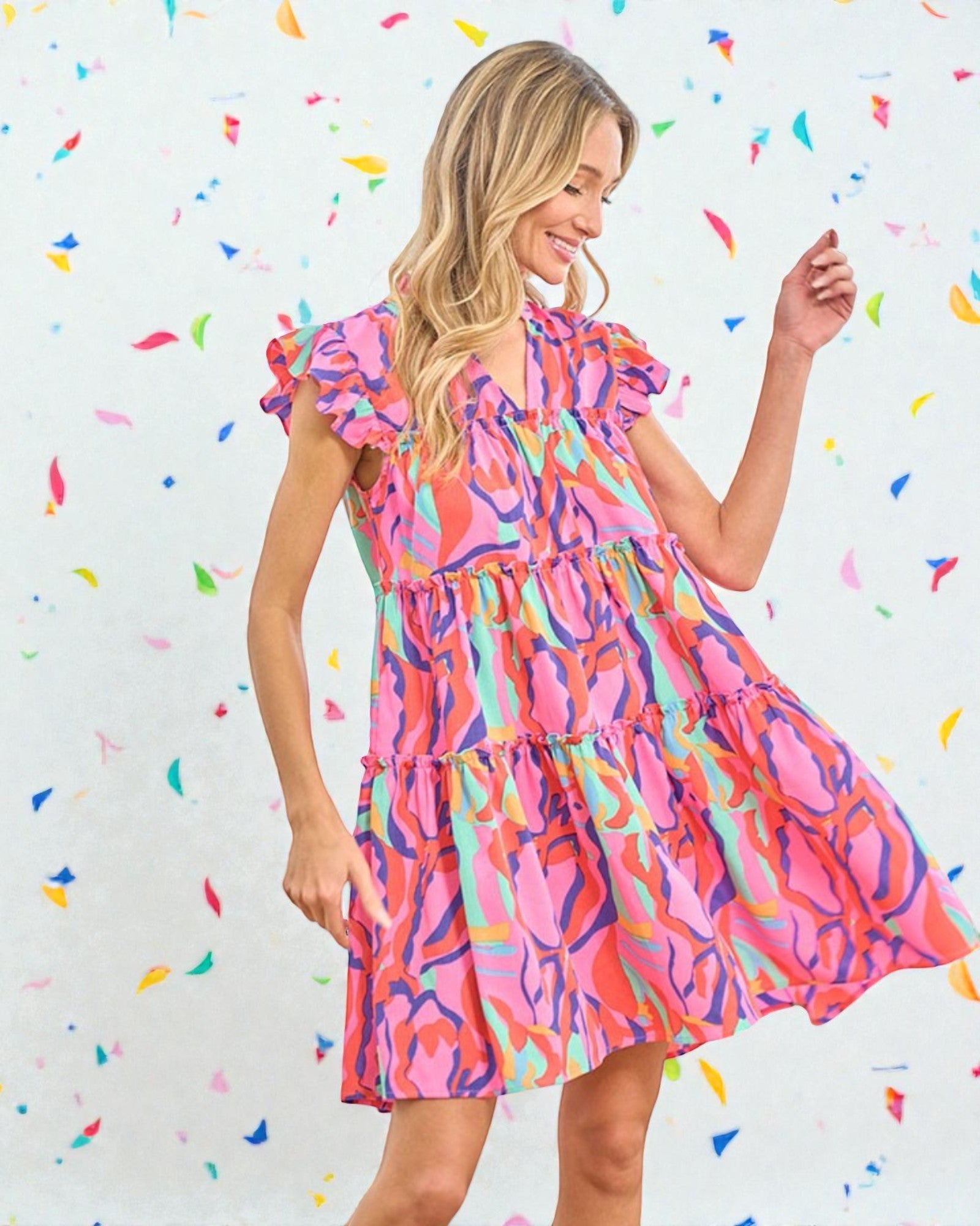 Woman wearing a colorful dress against a confetti-patterned background