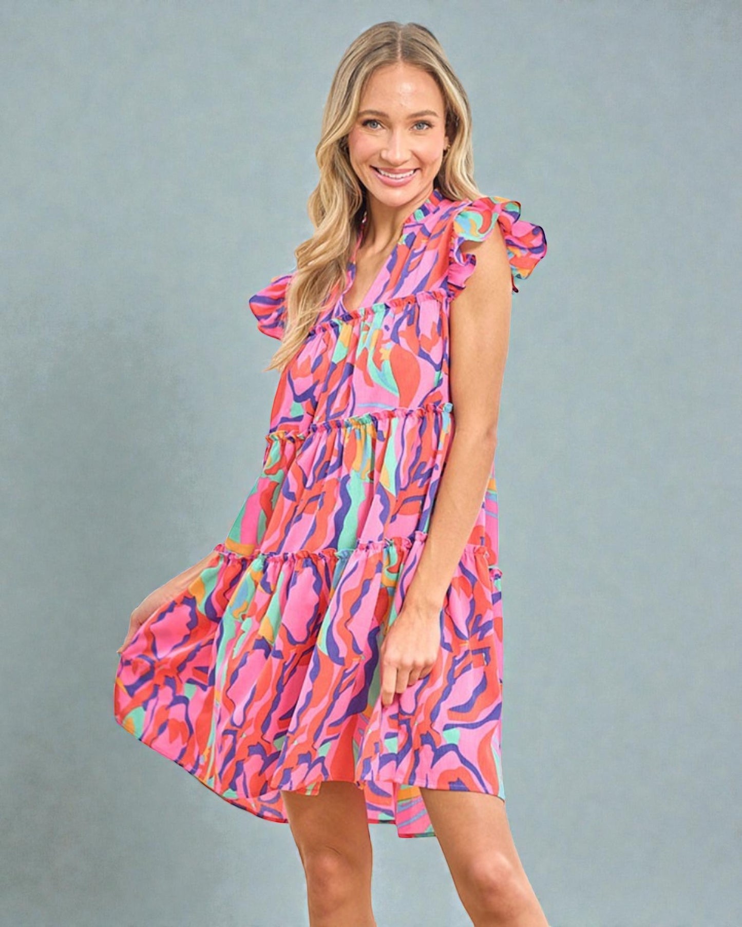 Woman wearing a colorful dress against a gray background