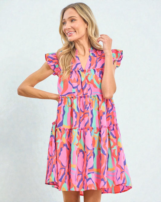 Woman wearing a colorful dress with a abstract pattern on a light blue background