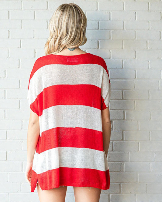 Person wearing a red and white striped shirt against a white brick wall.