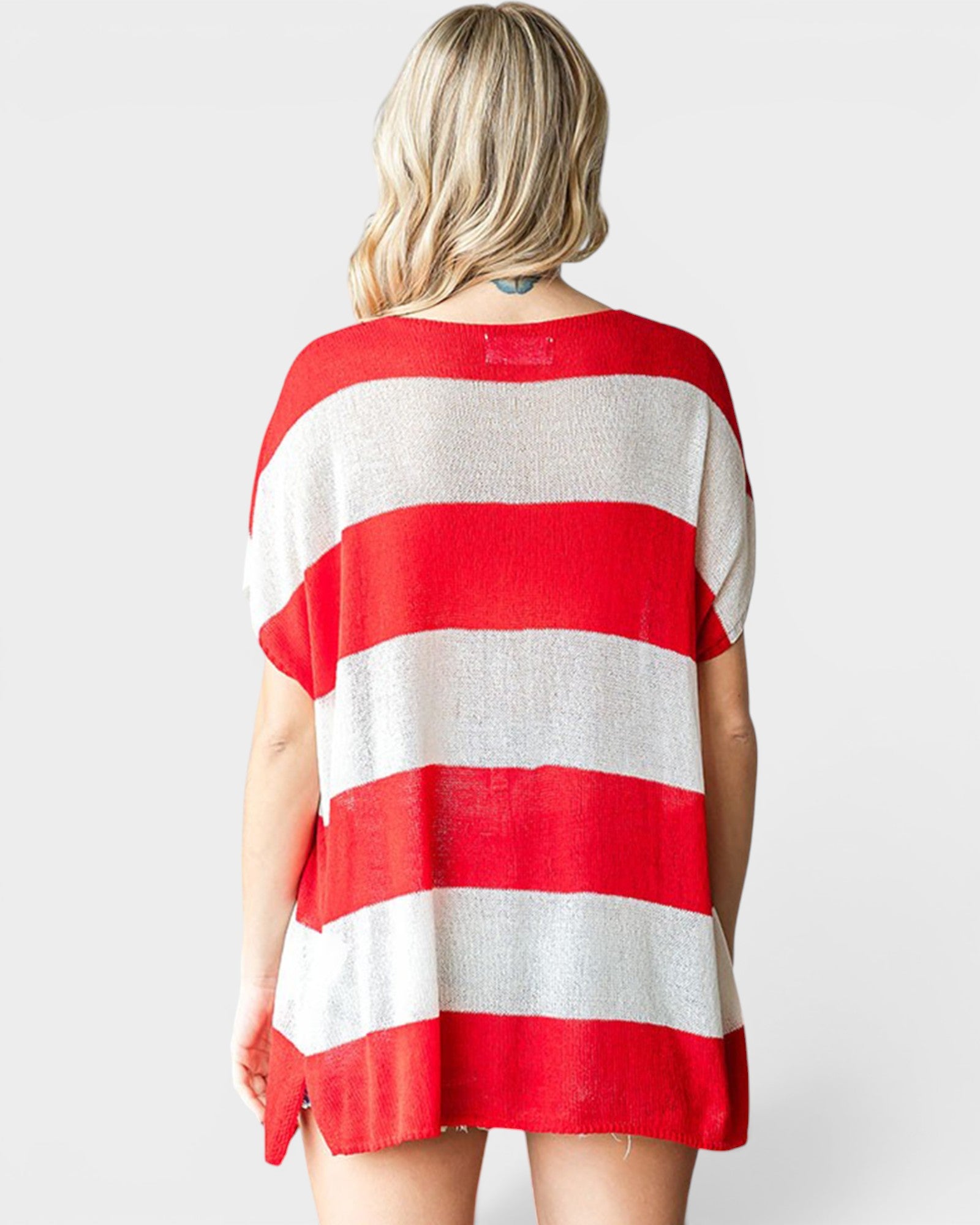 A woman shown from the back wearing a loose short-sleeve knit top with bold horizontal red and white stripes, photographed against a light gray studio background.
