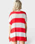 A woman shown from the back wearing a loose short-sleeve knit top with bold horizontal red and white stripes, photographed against a light gray studio background.