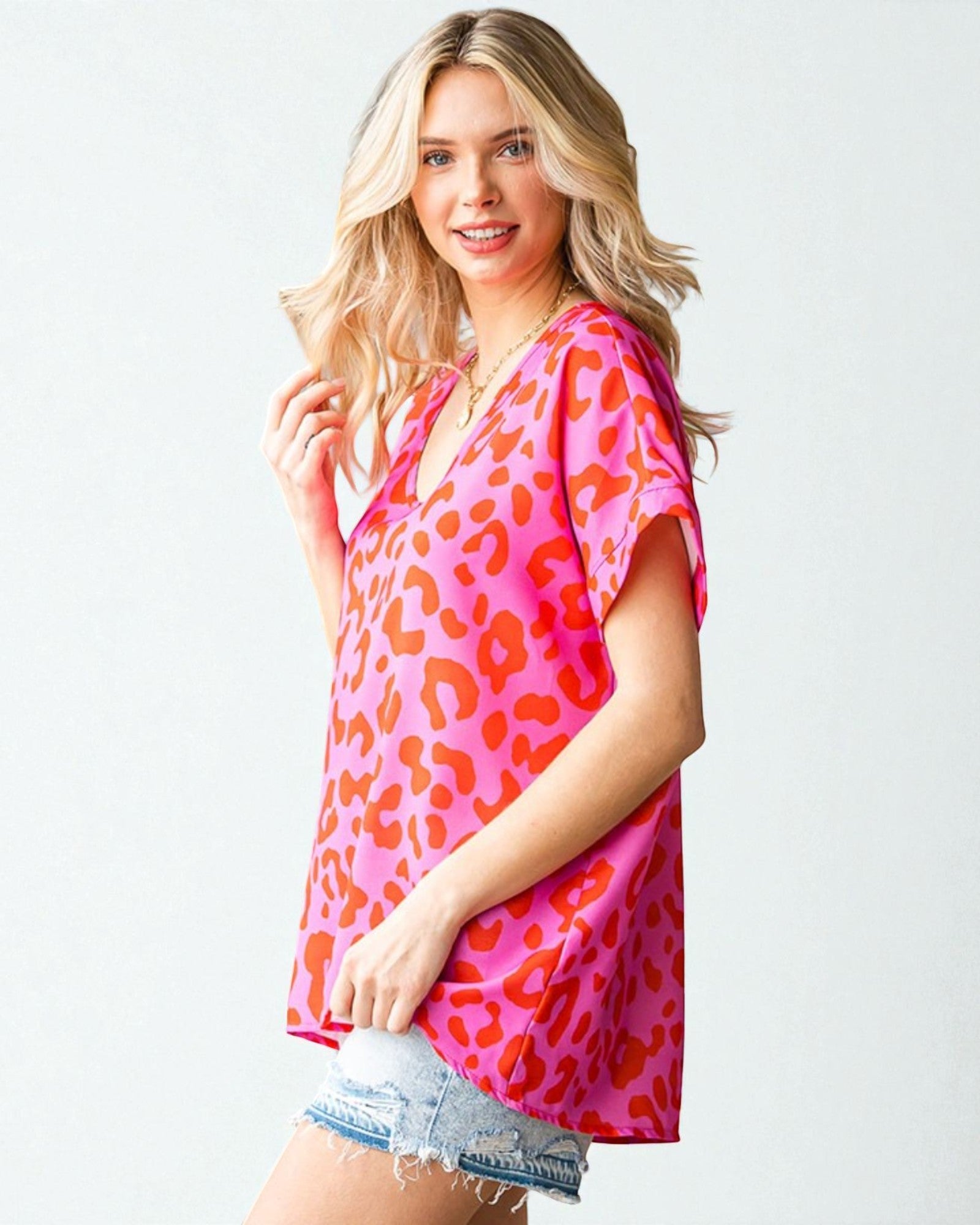 Woman wearing a pink leopard print top on a white background