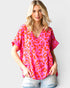 Woman wearing a pink leopard print top against a white background