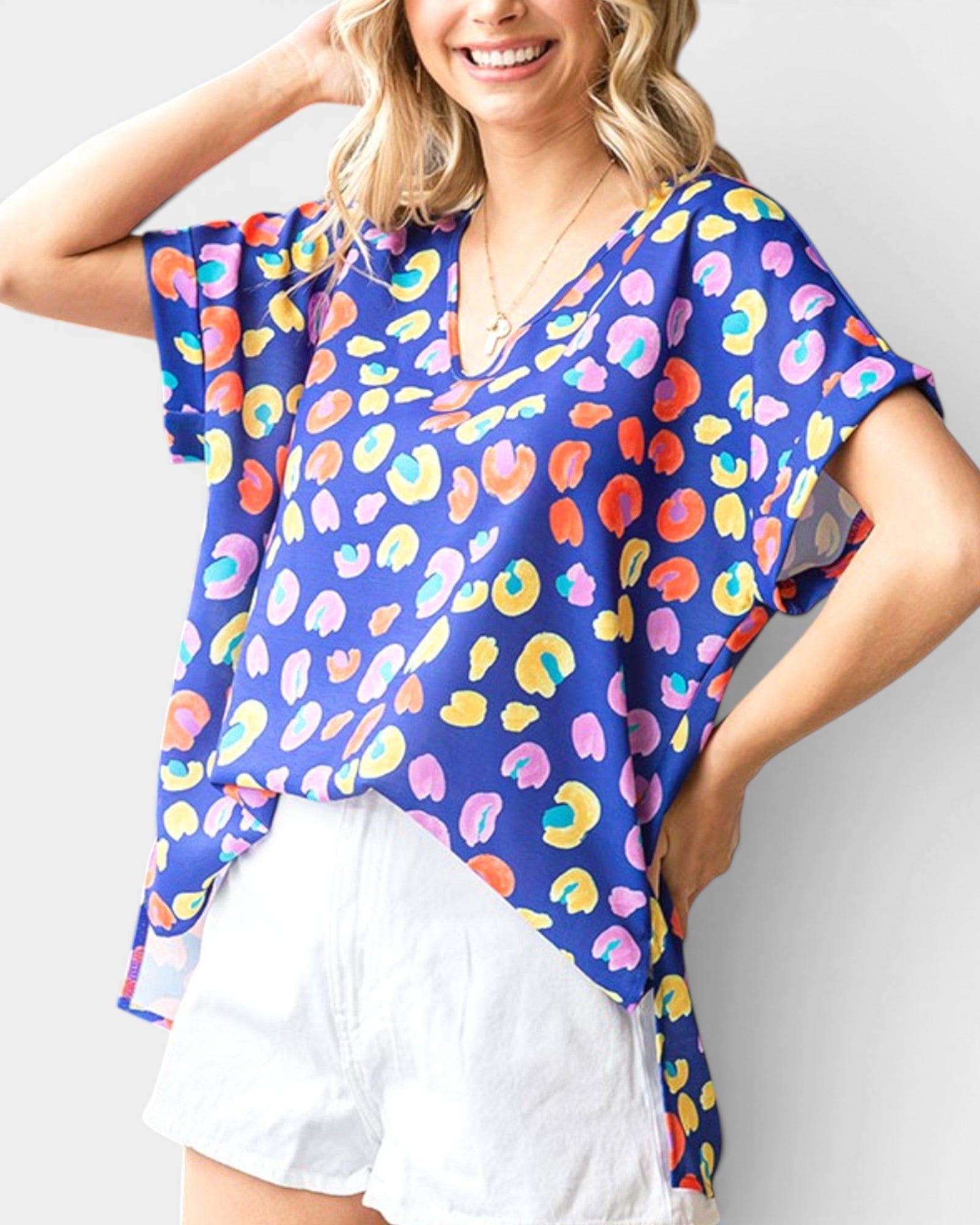Woman wearing a colorful patterned top with a plain background