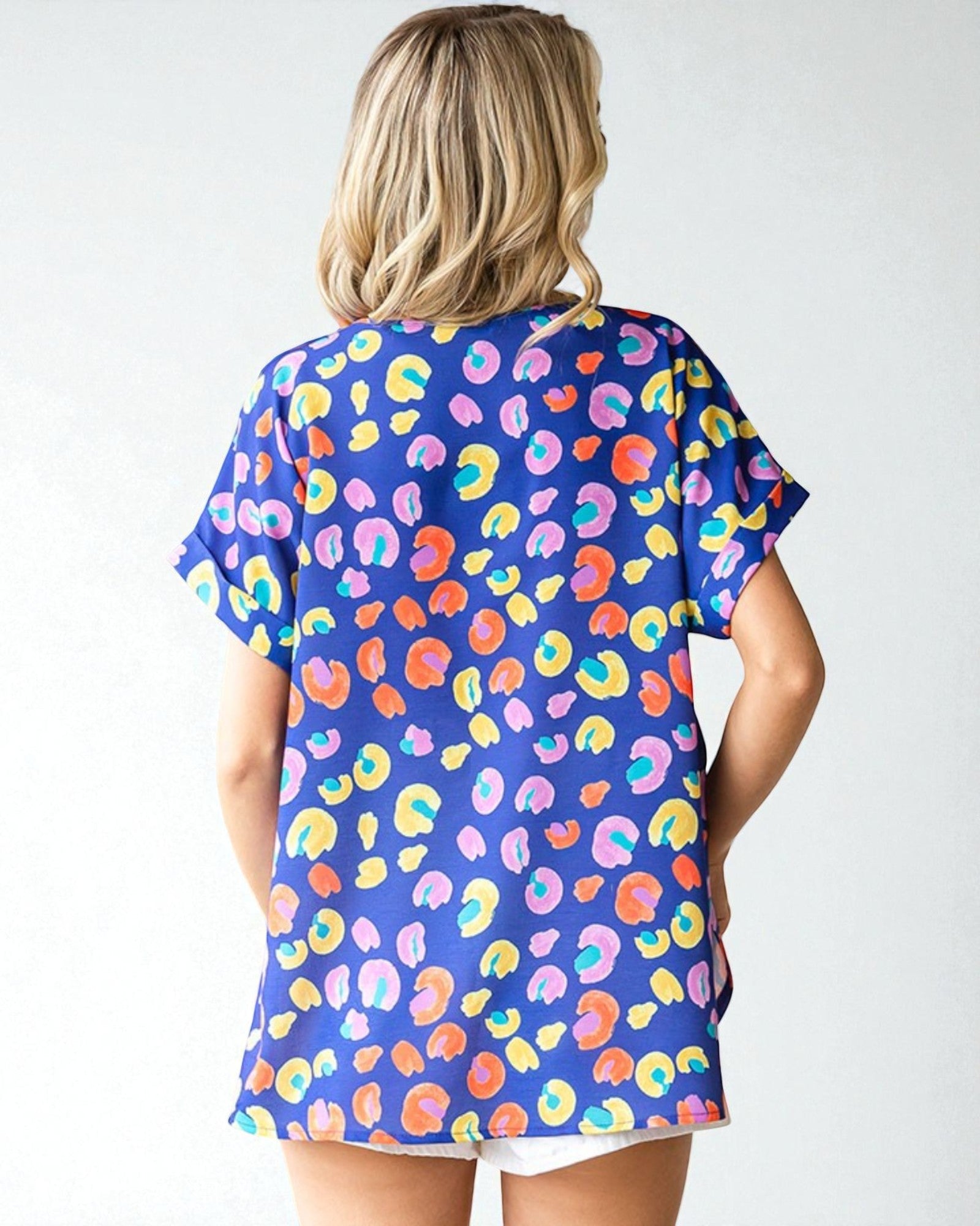 Woman wearing a colorful patterned shirt with a plain background