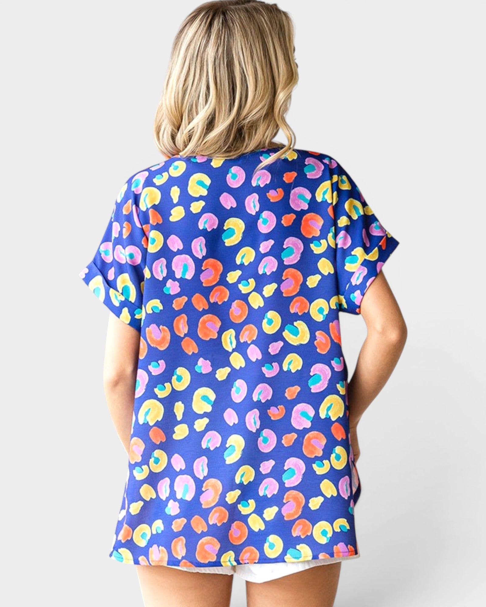 Woman wearing a colorful patterned shirt with a plain background