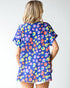 Woman wearing a colorful patterned shirt with a plain background