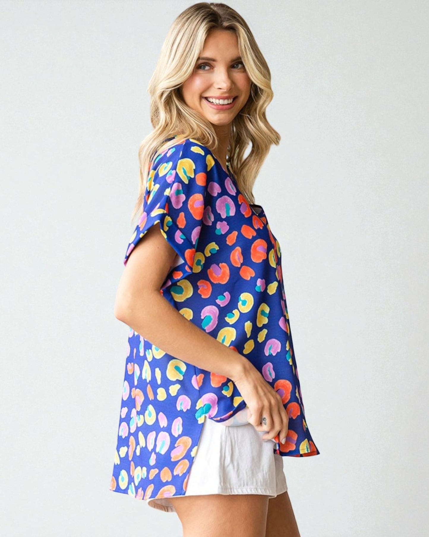Woman wearing a colorful patterned shirt with a plain background
