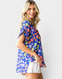 Woman wearing a colorful patterned shirt with a plain background