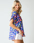 Woman wearing a colorful patterned shirt with a plain background