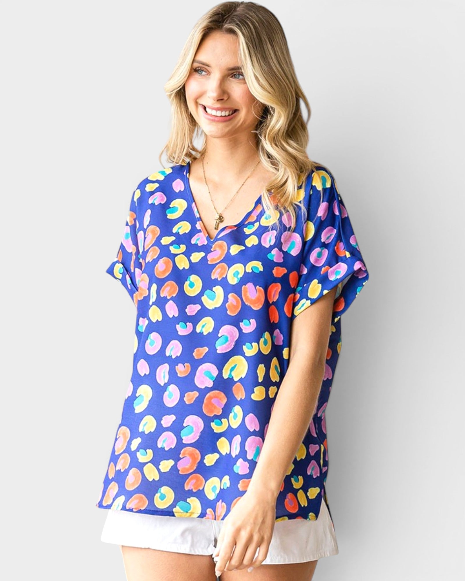 Woman wearing a colorful patterned shirt against a plain background
