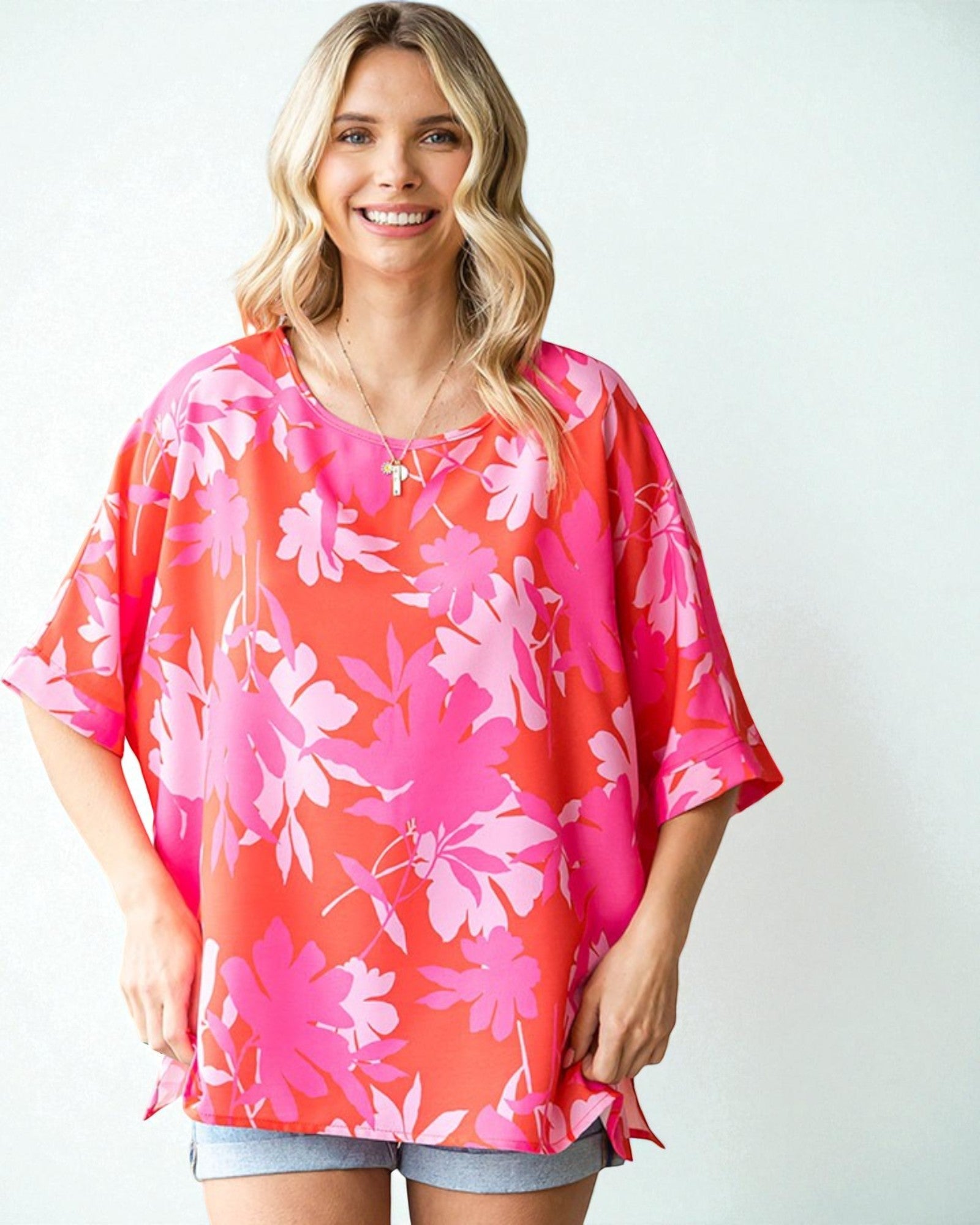 Woman wearing a pink floral blouse against a white background