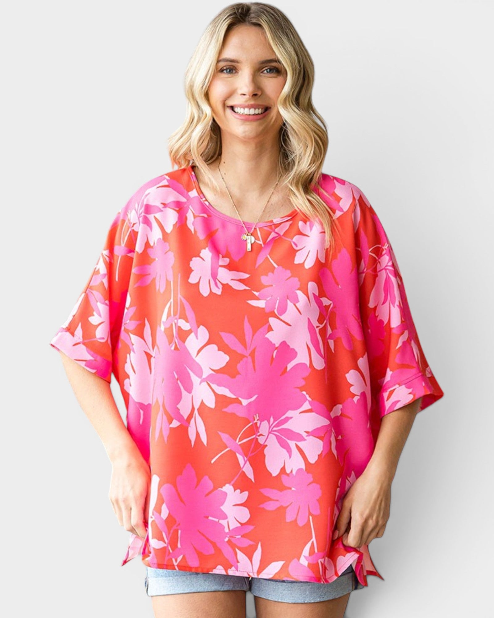 Woman wearing a pink floral blouse against a white background