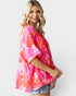 Woman wearing a pink floral kimono against a white background