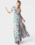 Woman wearing a colorful floral dress on a white background