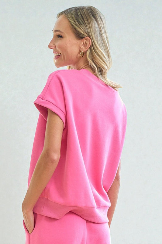 Woman wearing a pink outfit against a plain background