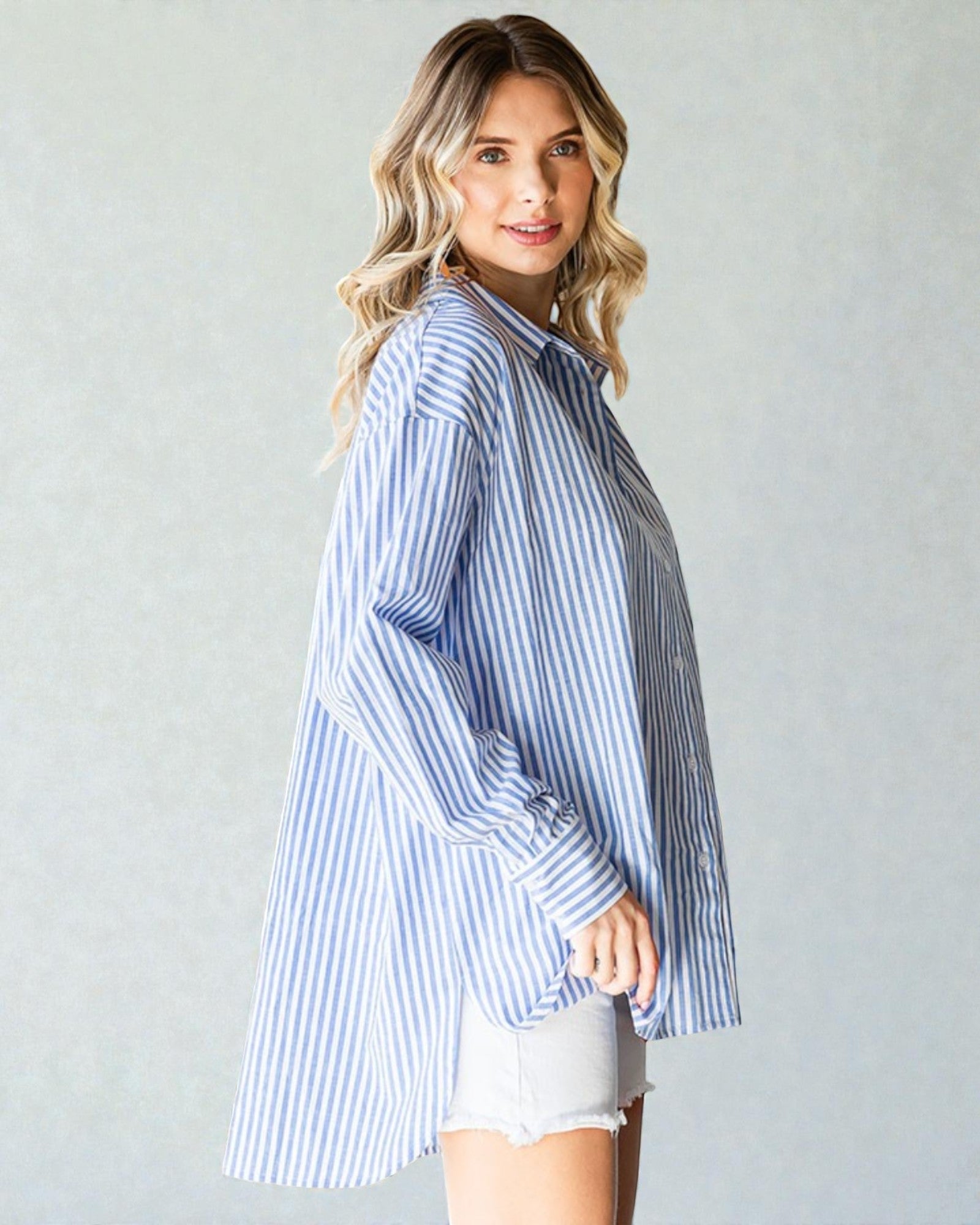 Woman wearing a blue and white striped shirt against a plain background