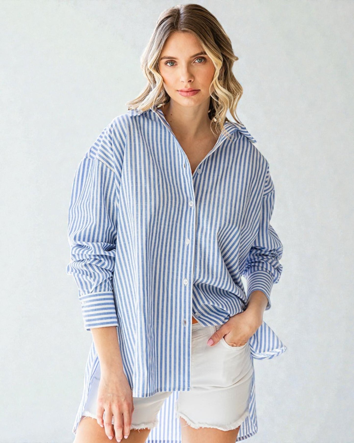 Woman wearing a blue and white striped shirt with a plain background