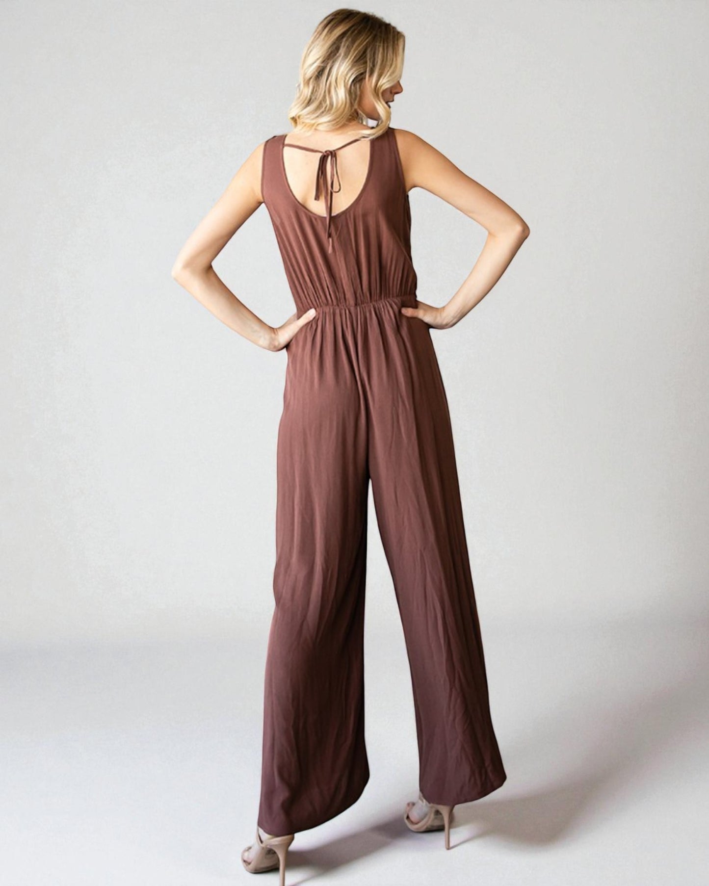 Woman wearing a brown jumpsuit on a white background