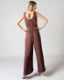 Woman wearing a brown jumpsuit on a white background