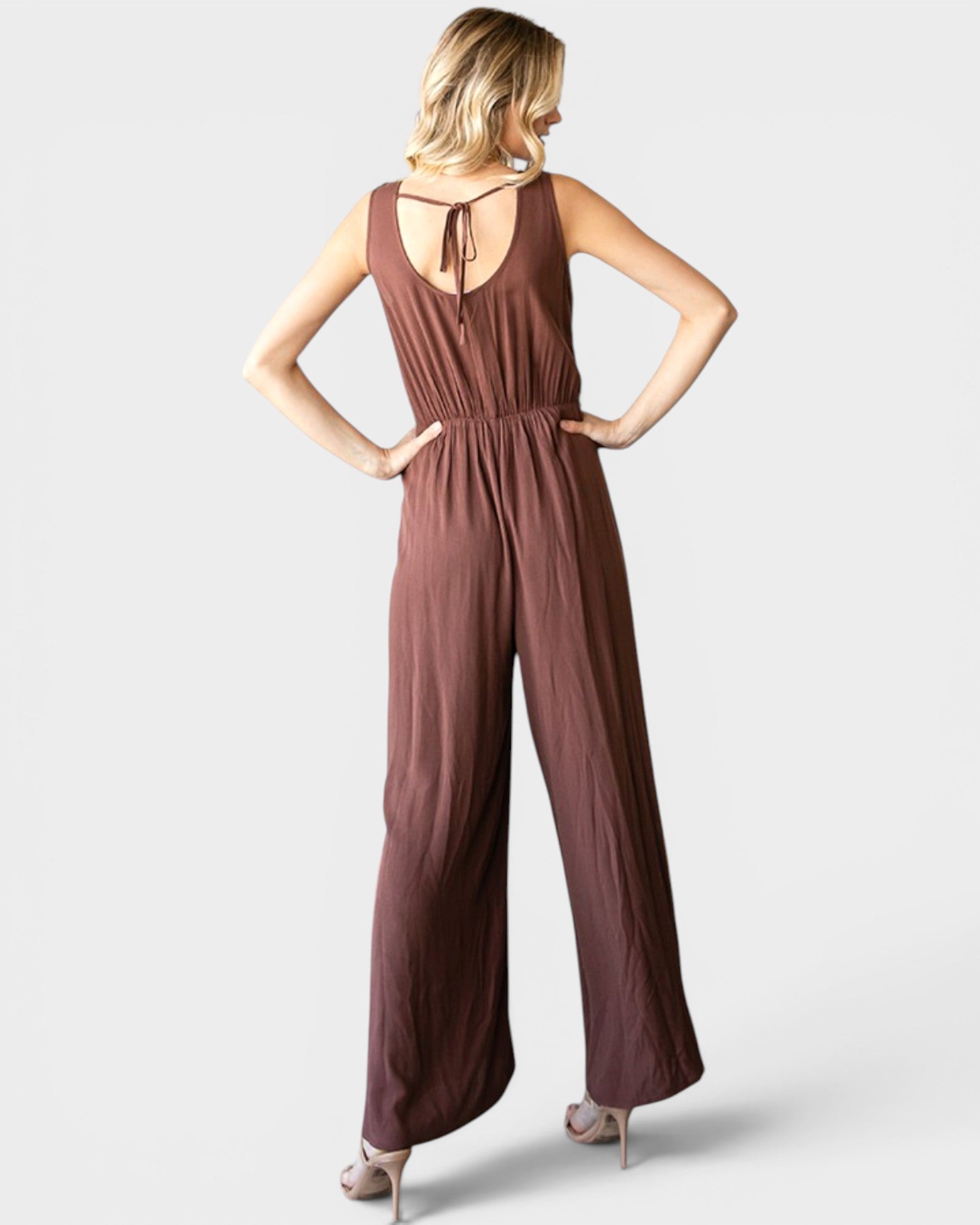 Woman wearing a brown jumpsuit on a white background