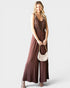 Woman wearing a brown dress holding a beige handbag on a white background