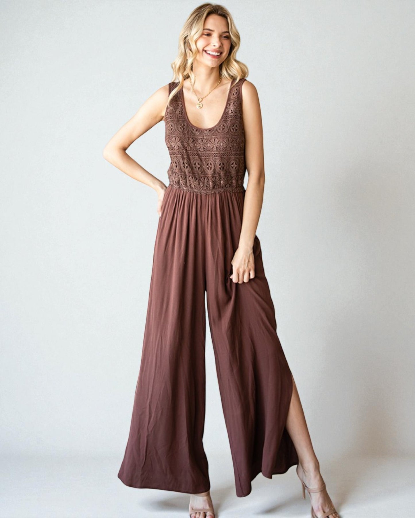 Woman wearing a brown jumpsuit with a patterned top against a white background