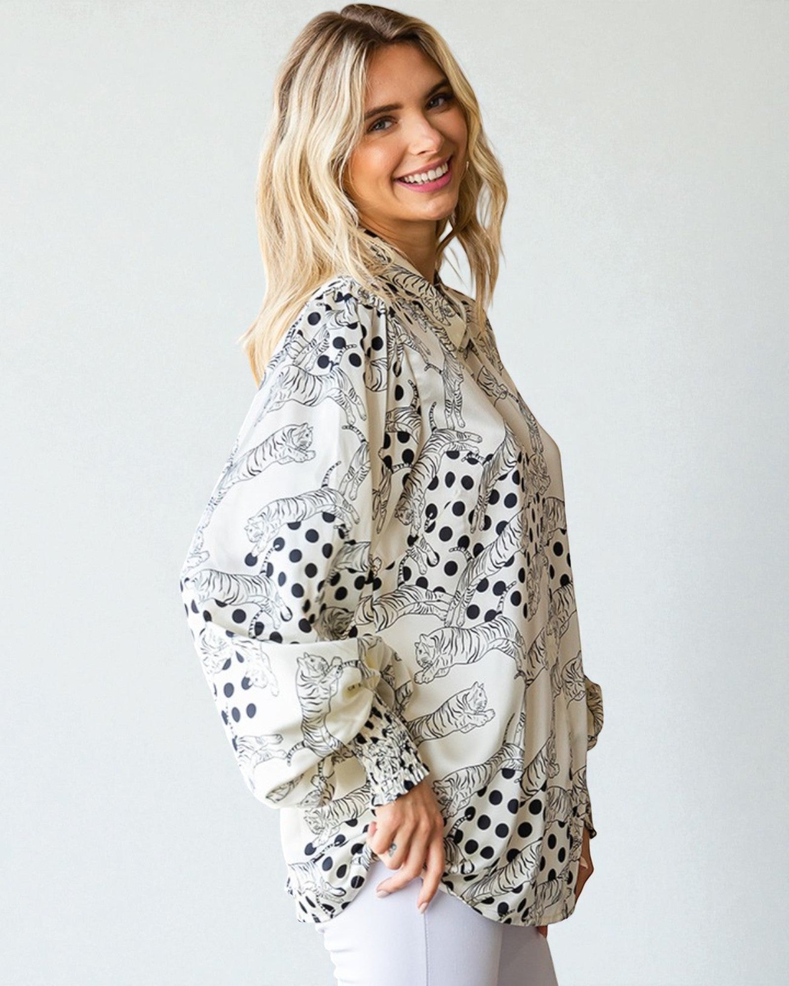 Woman wearing a patterned blouse against a white background