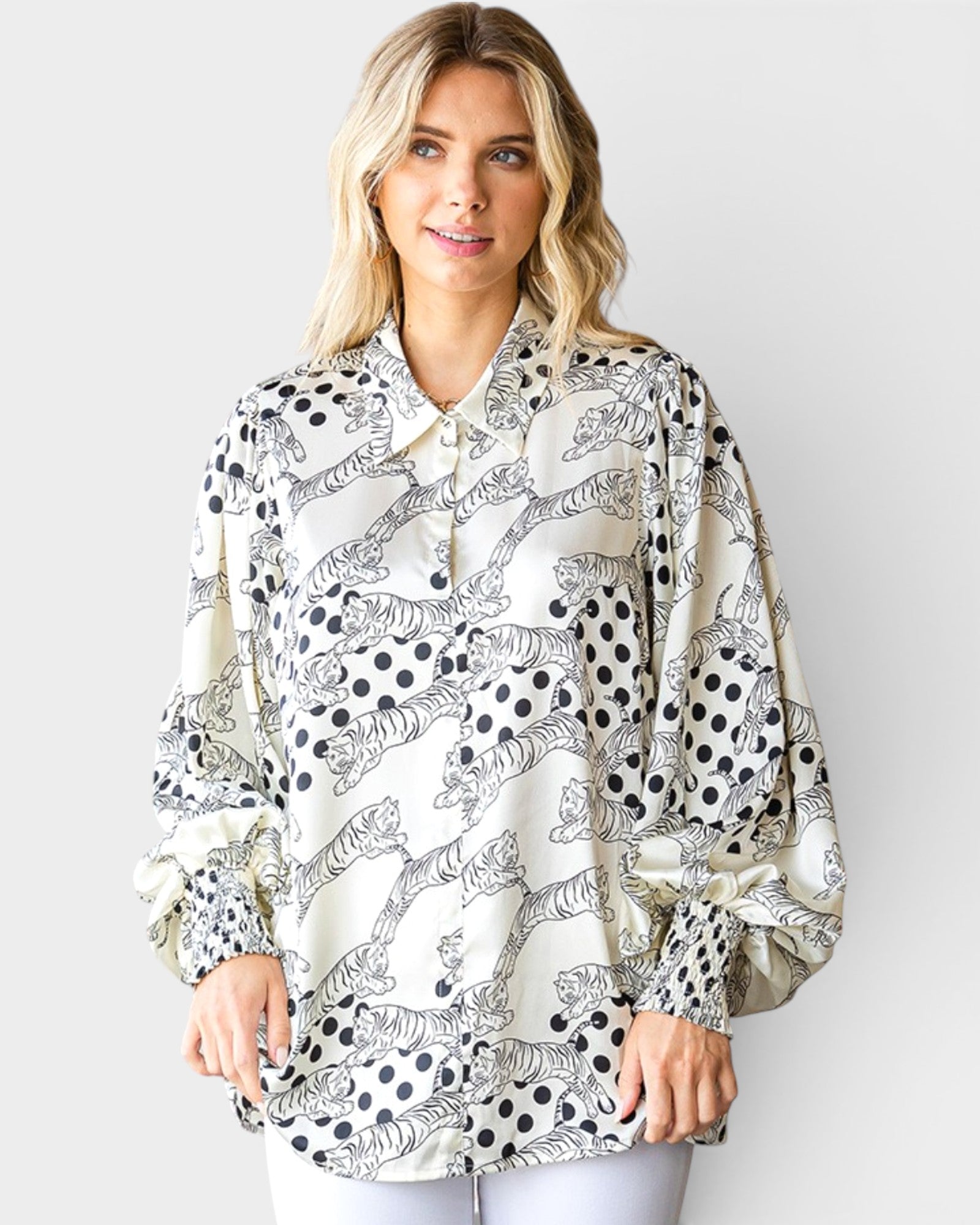 Woman wearing a black and white patterned blouse against a plain background