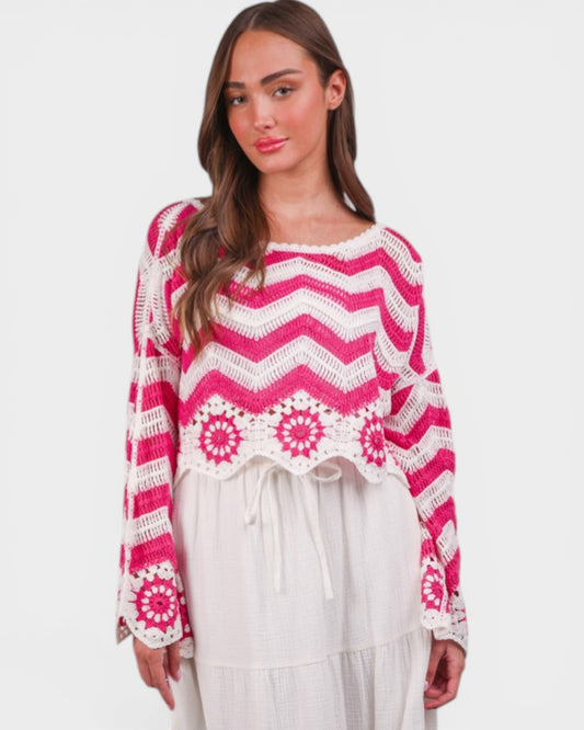 Woman wearing a pink and white patterned sweater on a white background