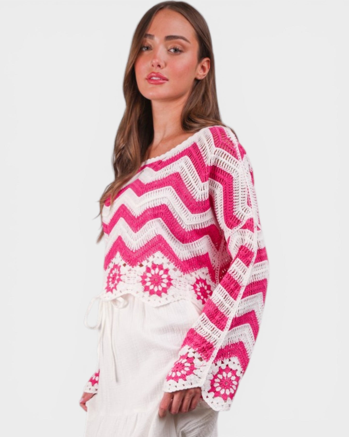 Woman wearing a pink and white patterned sweater on a white background