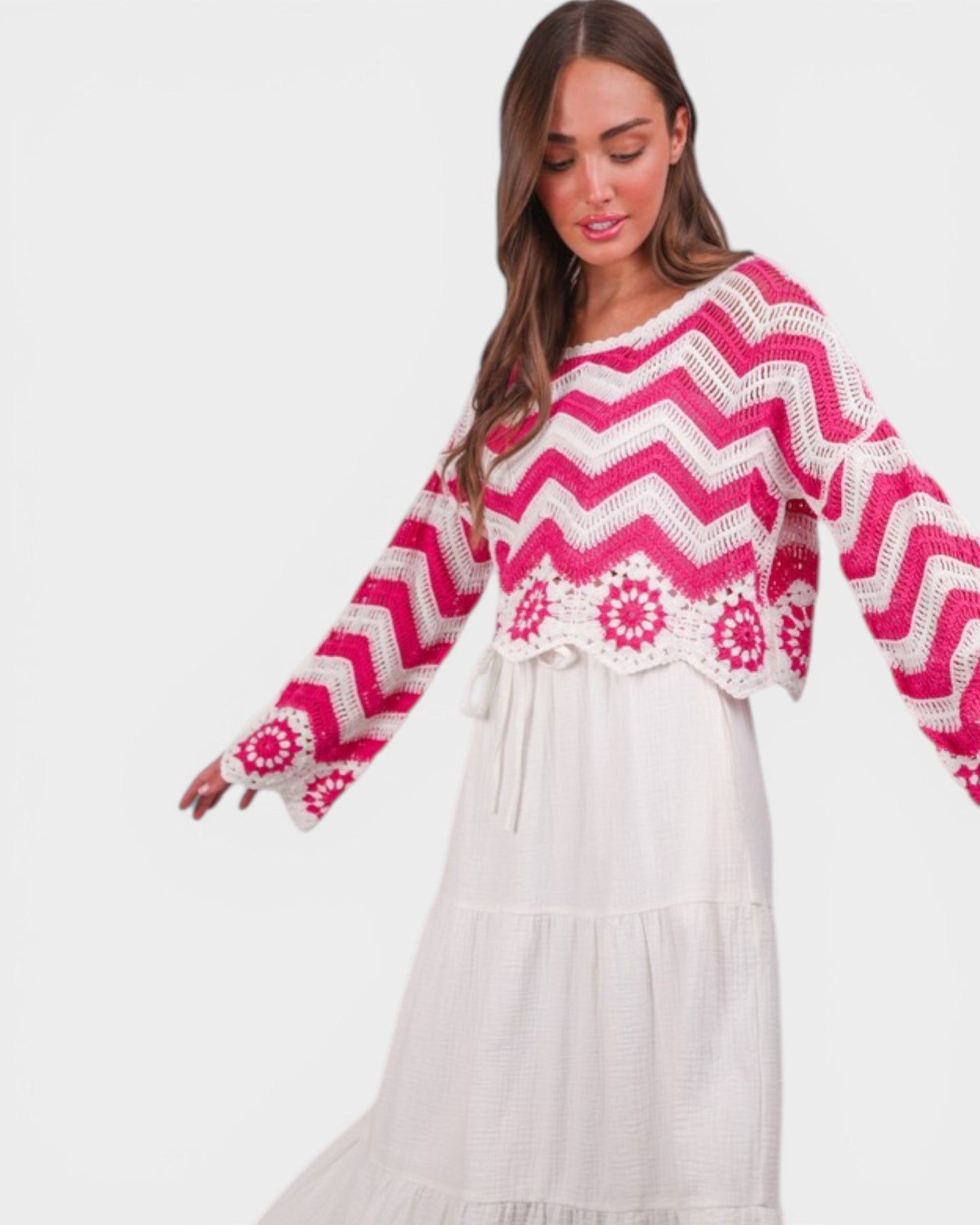 Woman wearing a pink and white chevron patterned top with a white skirt on a light gray background