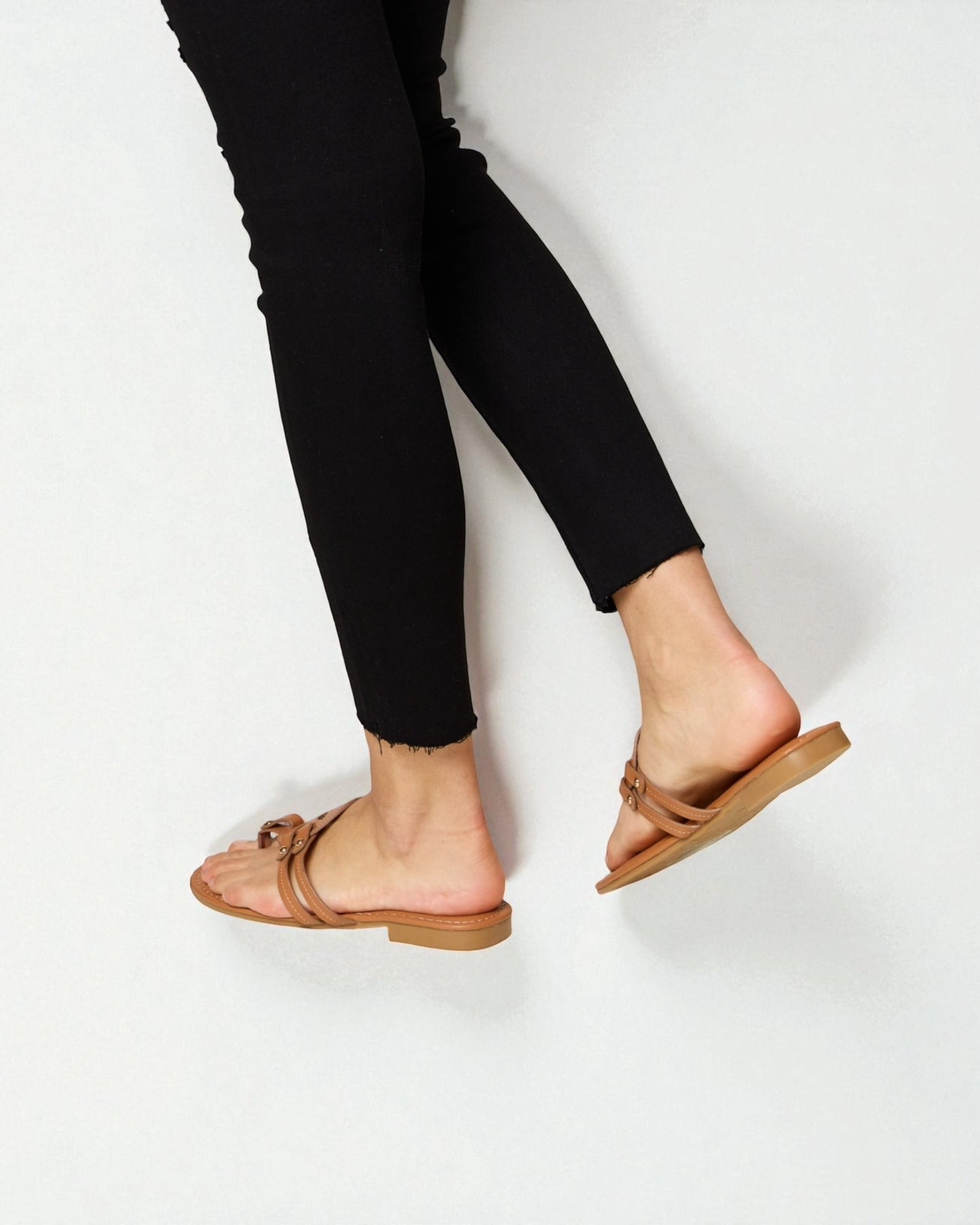 Person wearing brown sandals on a white background