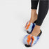 Colorful tie-dye slippers worn with black leggings on a white background