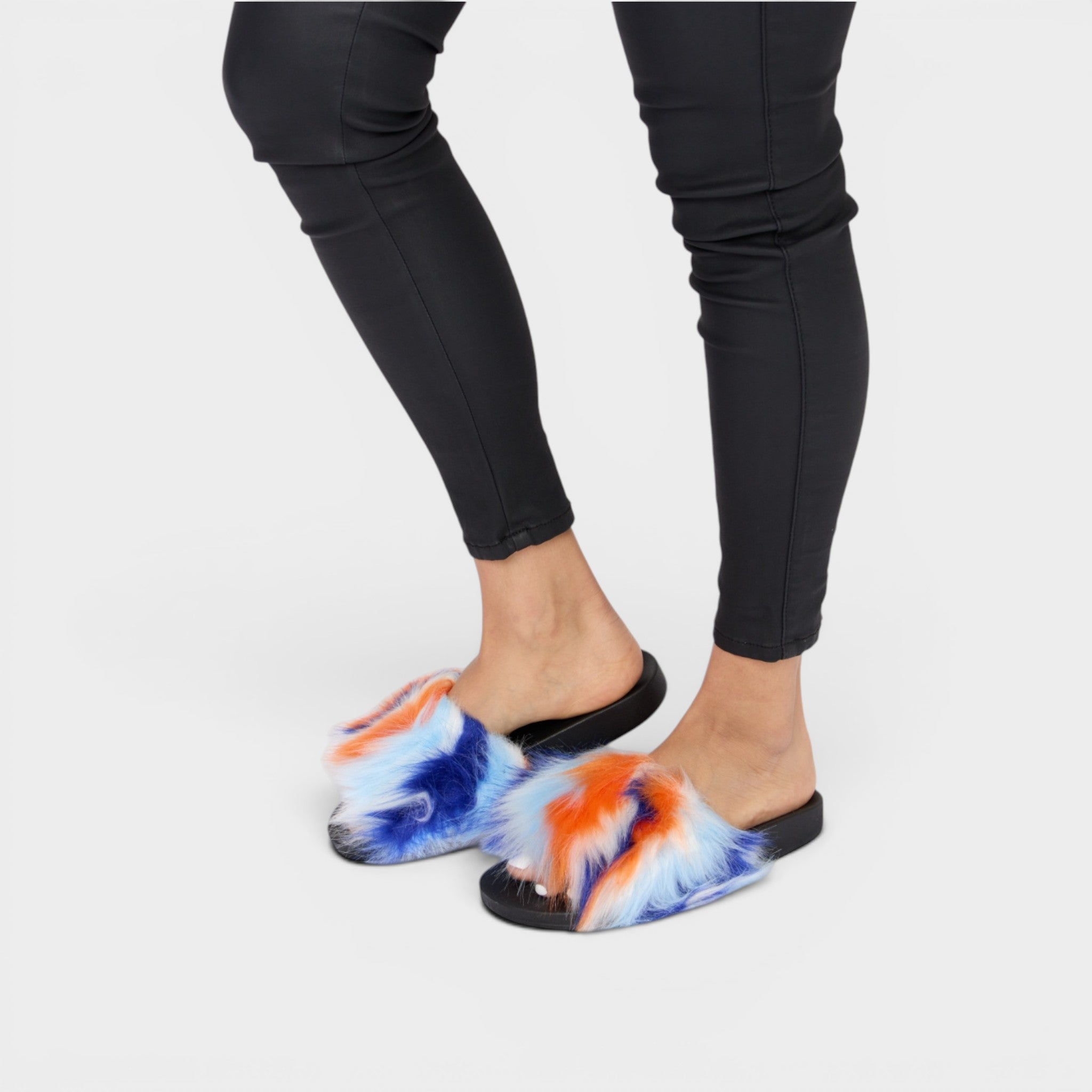 Tie-dye sandals worn with black leggings on a white background