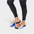 Tie-dye sandals worn with black leggings on a white background